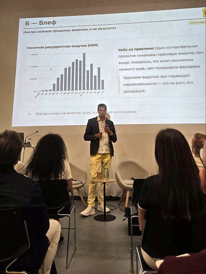 Sergei Bogdanov presenting a slide with a monthly revenue chart