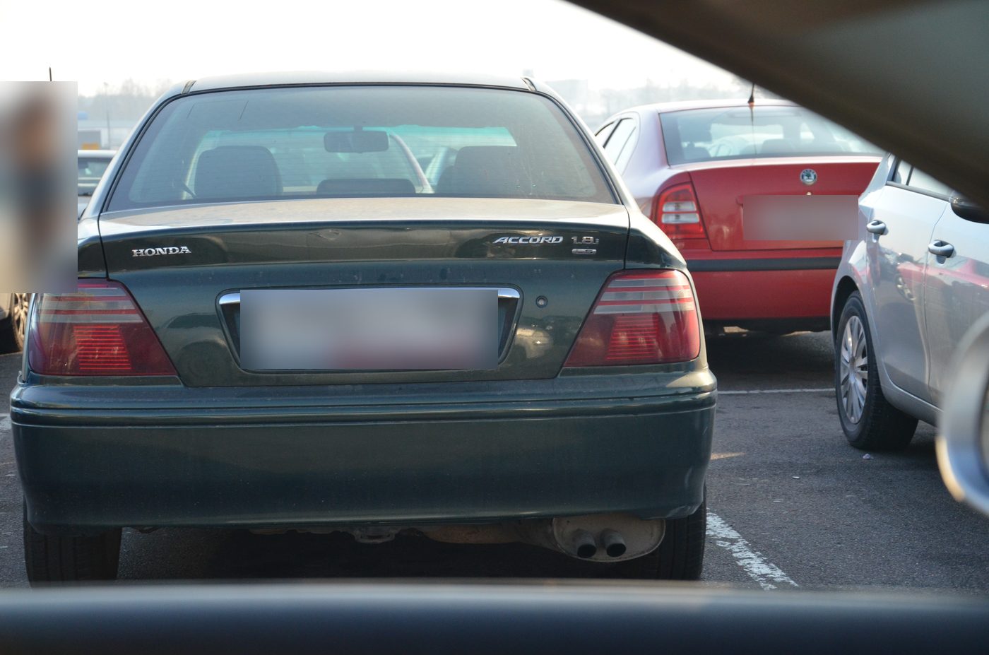 A frame from the dataset: the back of a car in a car park, shot from inside through the windscreen