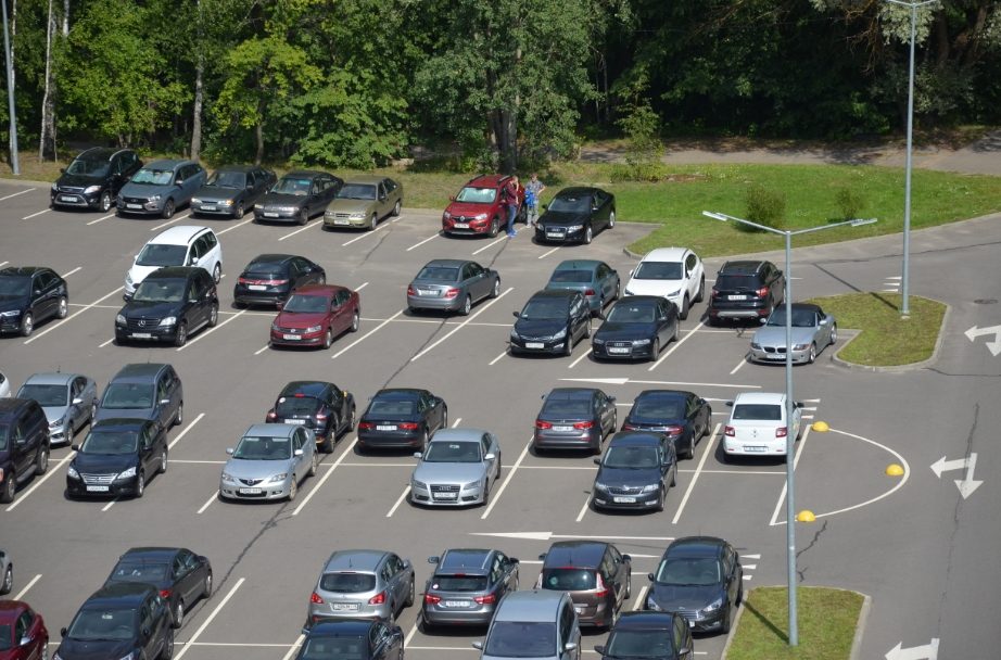 A large car park shot from above: dozens of cars in rows