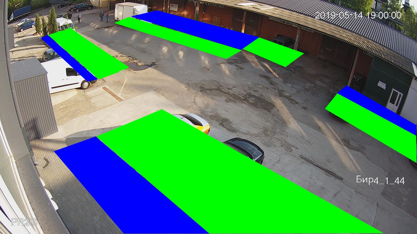 A courtyard camera frame with coloured markup: green parking zones, blue road lanes